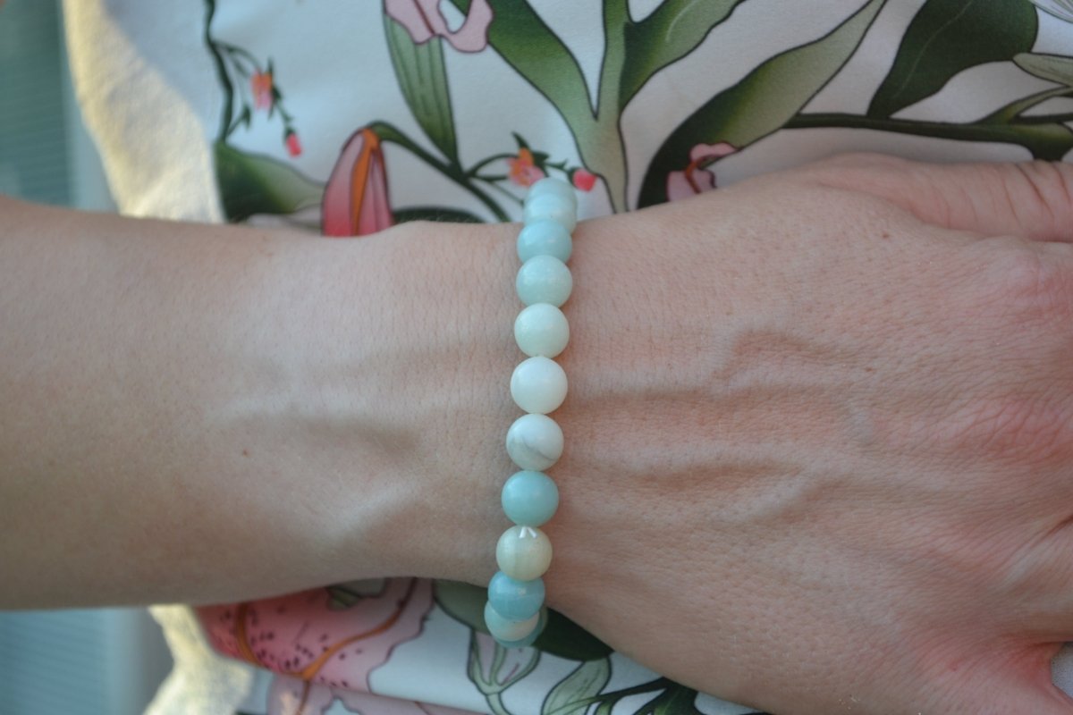 Bracelet Amazonite en pierre naturelle porté sur un poignet d'une femme au niveau du ventre. perle de diamètre 5-6mm