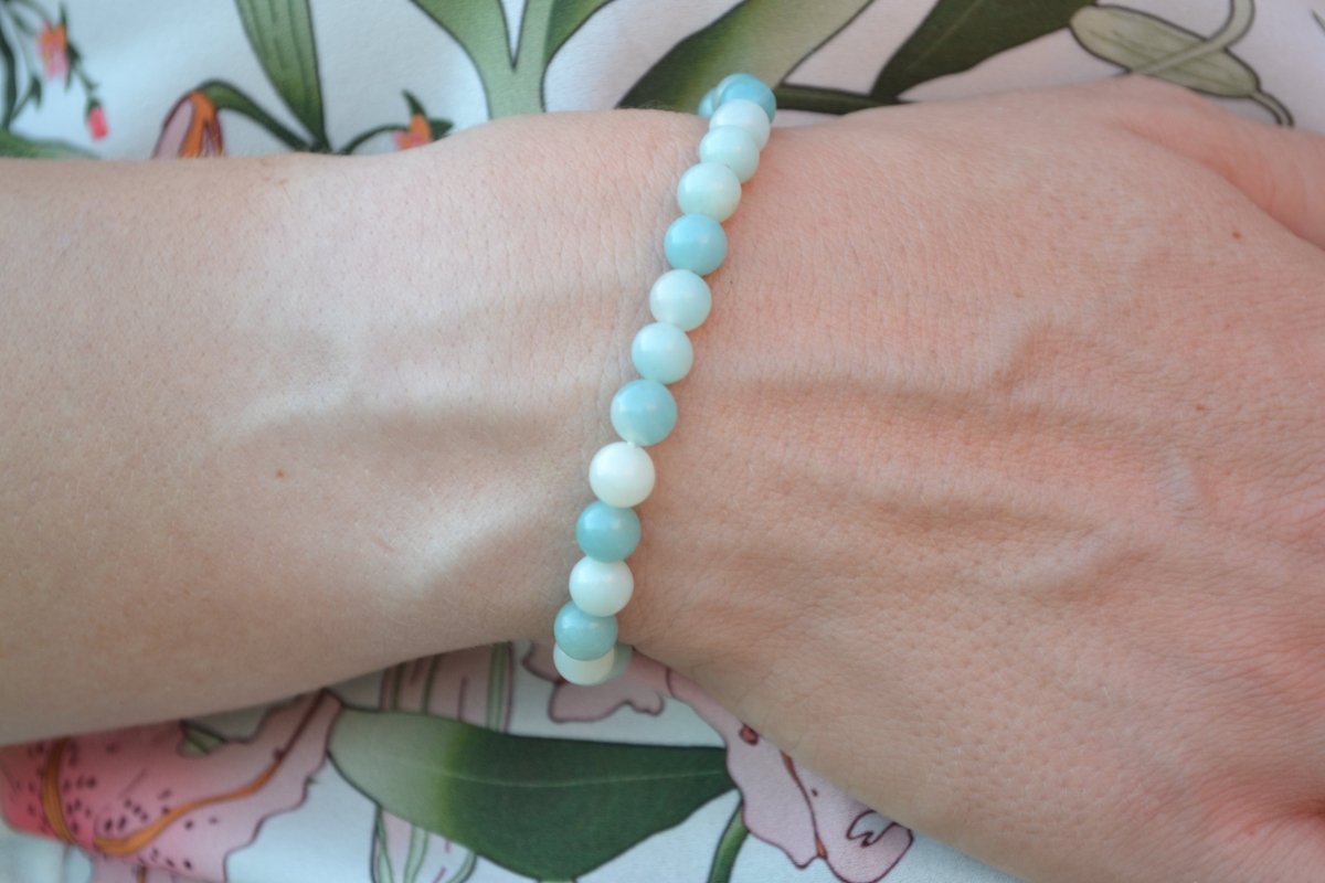 Bracelet Amazonite en pierre naturelle porté sur un poignet d'une femme au niveau du ventre. perle de diamètre 7-8mm