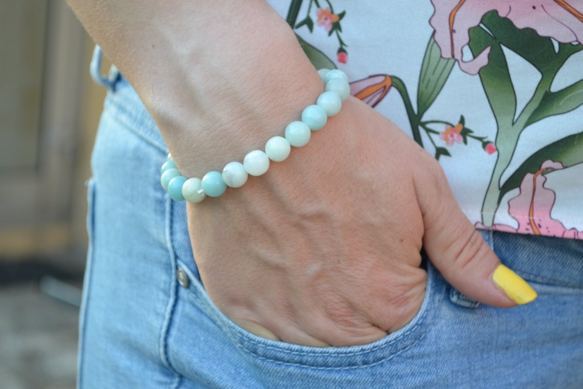 Bracelet Amazonite en pierre naturelle porté sur un poignet d'une femme au niveau de la hanche. perle de diamètre 7-8mm