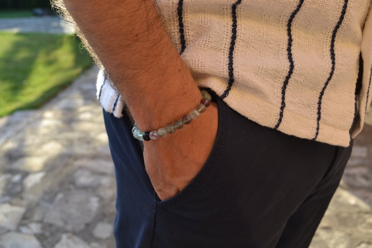 Bracelet Fluorite en pierre naturelle porté sur un poignet d'un homme au niveau de la hanche. perle de diamètre 7-8mm