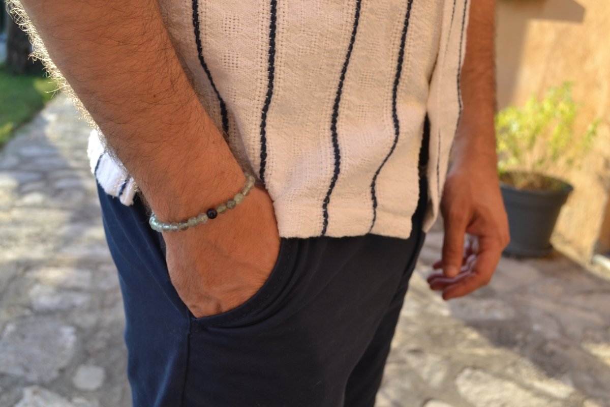 Bracelet Fluorite en pierre naturelle porté sur un poignet d'un homme au niveau de la hanche. perle de diamètre 5-6mm
