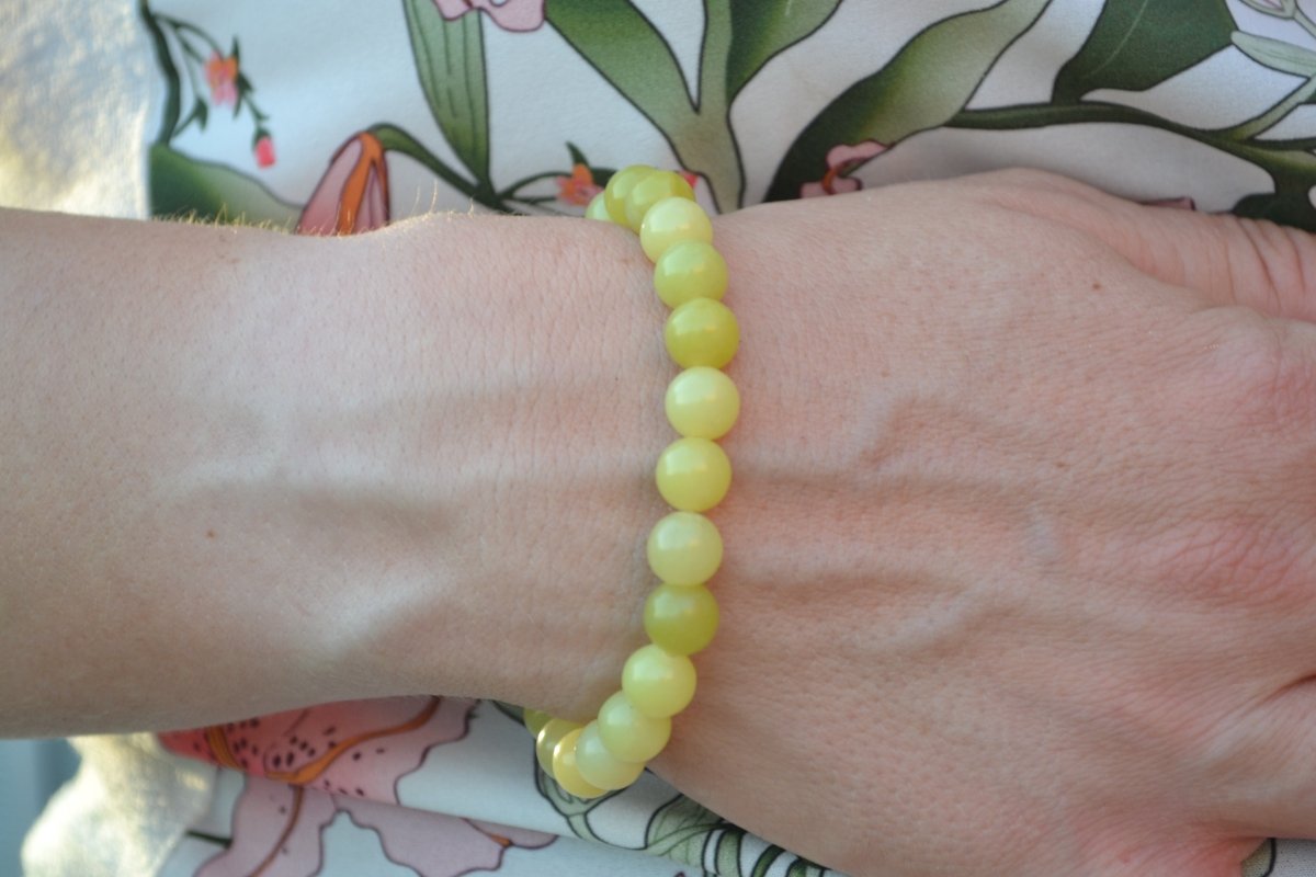 Bracelet Jade Citron en pierre naturelle porté sur un poignet d'une femme au niveau du ventre. perle de diamètre 7-8mm
