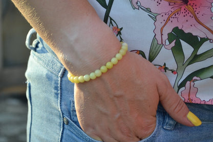 Bracelet Jade Citron en pierre naturelle porté sur un poignet d'une femme au niveau de la hanche. perle de diamètre 5-6mm