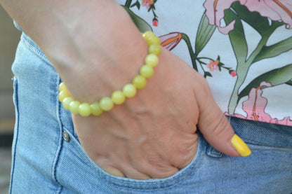 Bracelet Jade Citron en pierre naturelle porté sur un poignet d'une femme au niveau de la hanche. perle de diamètre 7-8mm