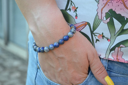 Bracelet Lapis Lazuli en pierre naturelle porté sur un poignet d'une femme au niveau de la hanche. perle de diamètre 7-8mm