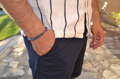 Bracelet Lapis Lazuli en pierre naturelle porté sur un poignet d'un homme au niveau de la hanche. perle de diamètre 5-6mm