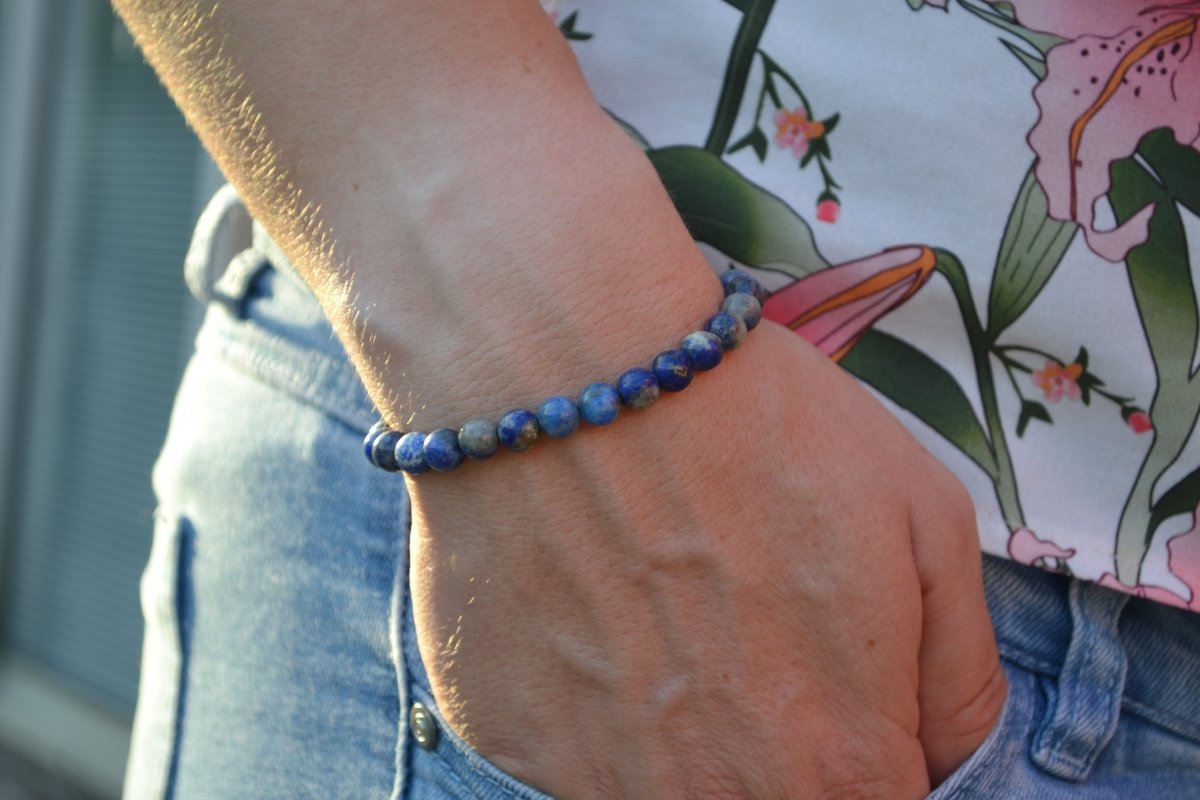 Bracelet Lapis Lazuli en pierre naturelle porté sur un poignet d'une femme au niveau de la hanche. perle de diamètre 5-6mm