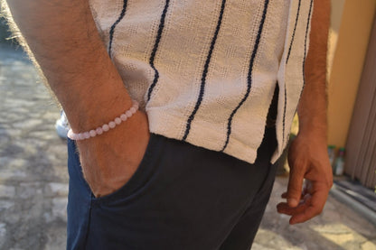 Bracelet Quartz Rose en pierre naturelle porté sur un poignet d'un homme au niveau de la hanche. perle de diamètre 5-6mm