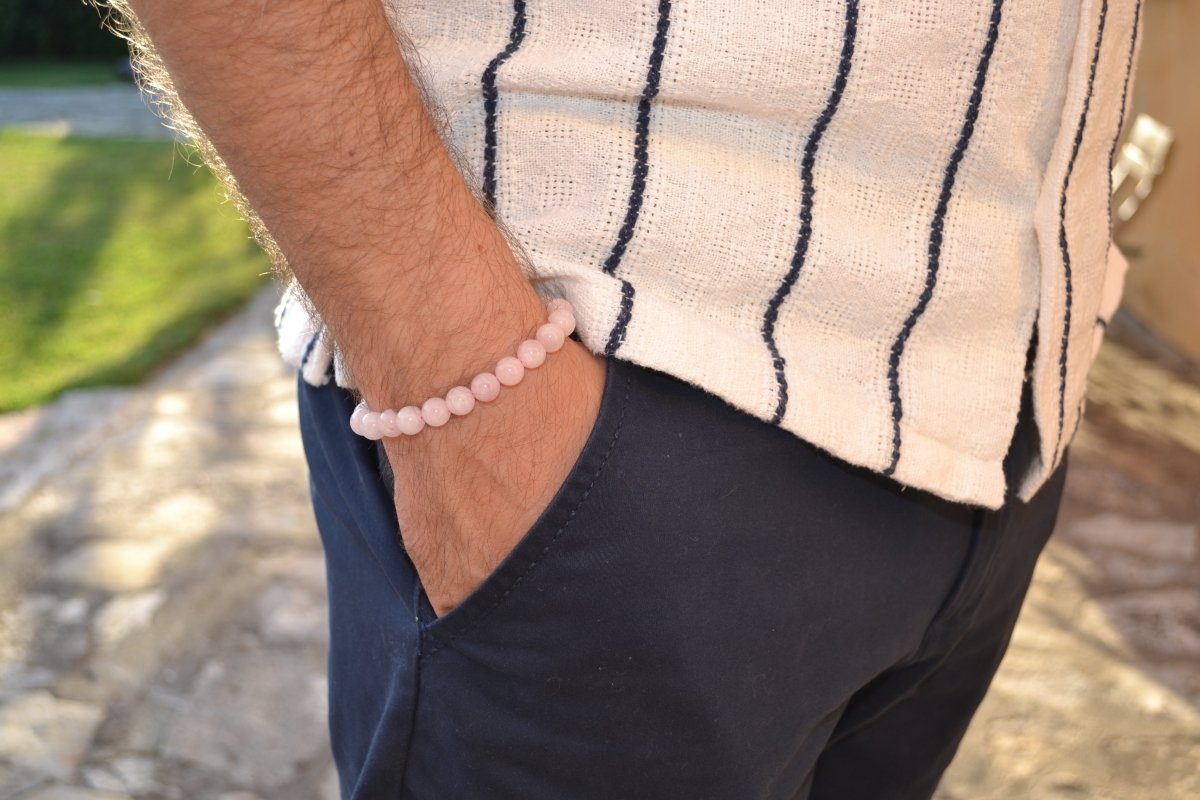 Bracelet Quartz Rose en pierre naturelle porté sur un poignet d'un homme au niveau de la hanche. perle de diamètre 7-8mm
