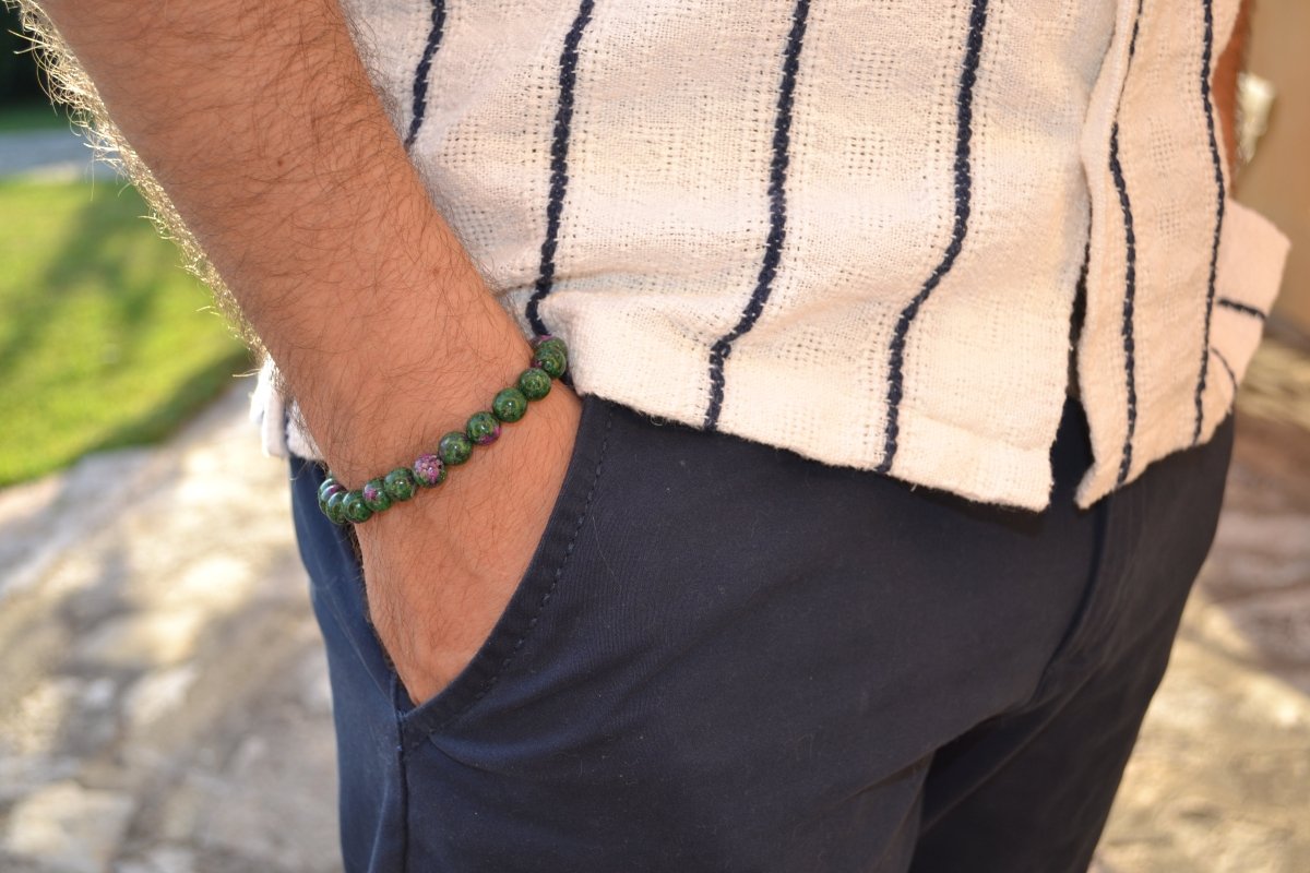 Bracelet Rubis Zoïsite en pierre naturelle porté sur un poignet d'un homme au niveau de la hanche. perle de diamètre 7-8mm