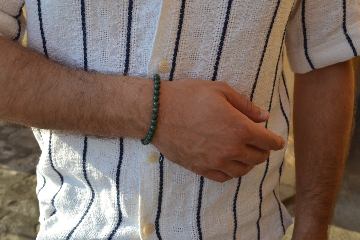 Bracelet Rubis Zoïsite en pierre naturelle porté sur un poignet d'un homme au niveau du ventre. perle de diamètre 7-8mm