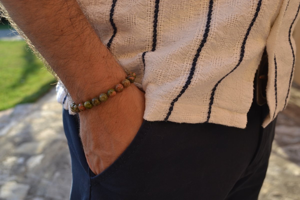 Bracelet Unakite en pierre naturelle porté sur un poignet d'un homme au niveau de la hanche. perle de diamètre 7-8mm