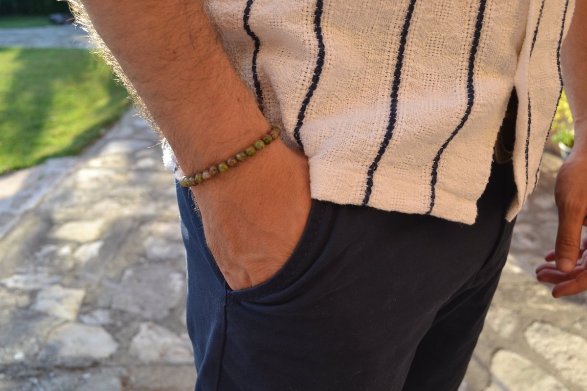 Bracelet Unakite en pierre naturelle porté sur un poignet d'un homme au niveau de la hanche. perle de diamètre 5-6mm