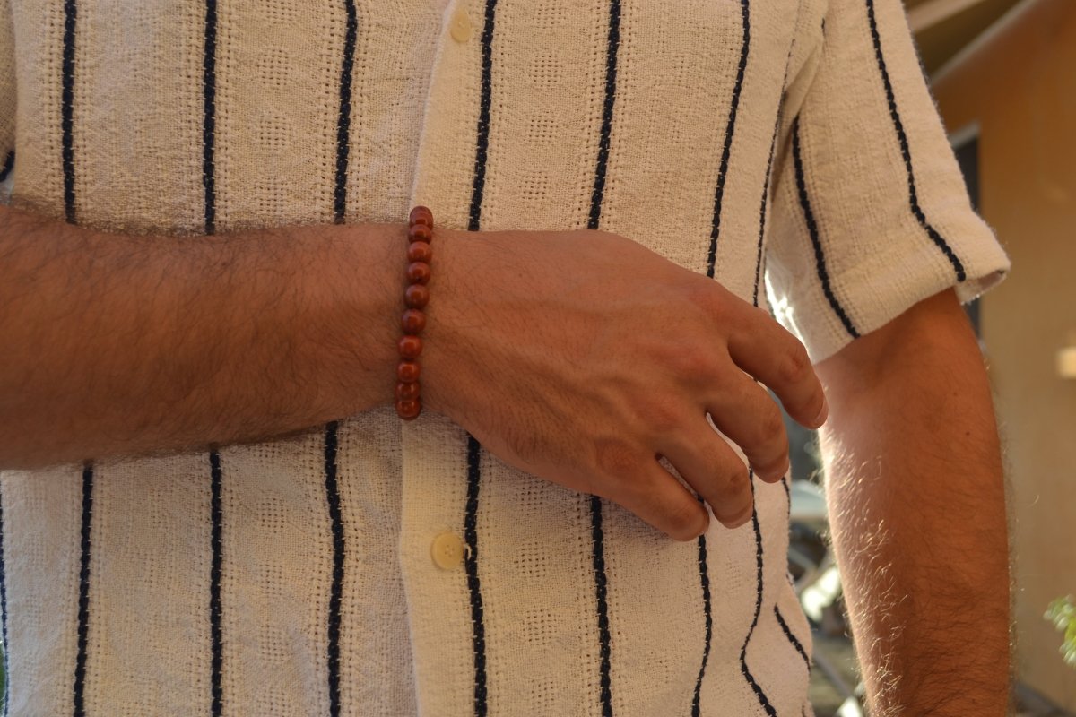 Bracelet Jaspe Rouge en pierre naturelle porté sur un poignet d'un homme. perle de diamètre 7-8mm